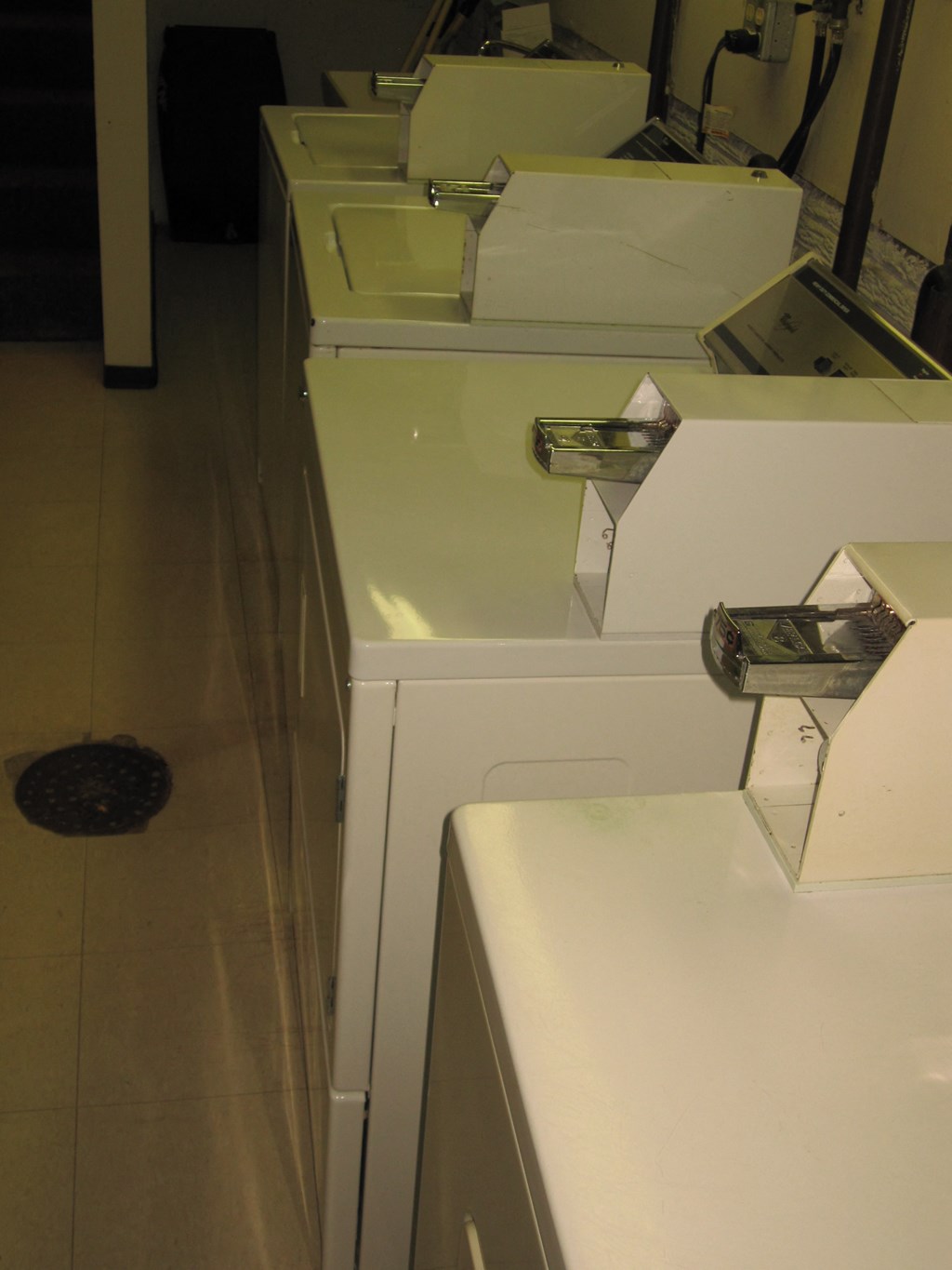 a row of sinks in a room with white cabinets
