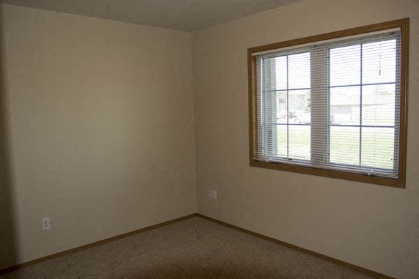 an empty room with a window and a carpet