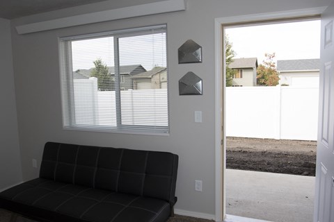 a living room with a black couch and a window