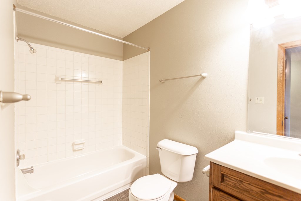 a bathroom with a toilet and a tub and a sink