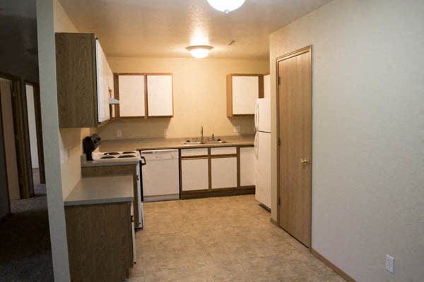 a kitchen with white cabinets and a sink and a refrigerator