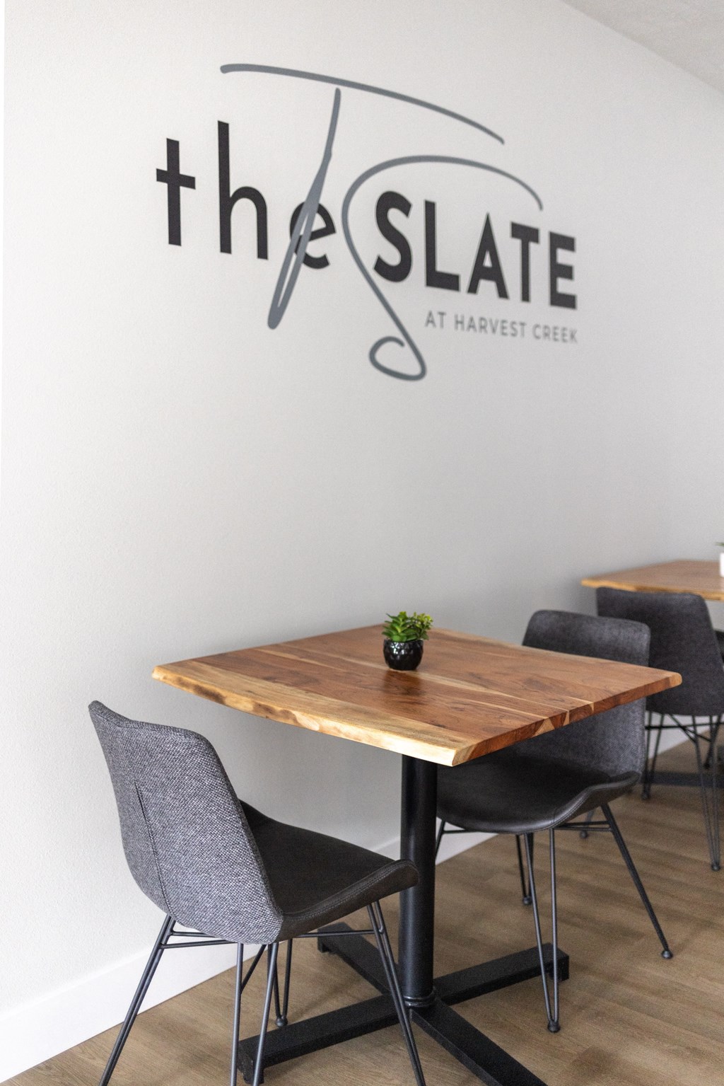 a communal table with chairs in a restaurant with the slate at harvest creek wall sticker