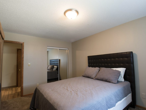 a bedroom with a bed and a door to a bathroom
