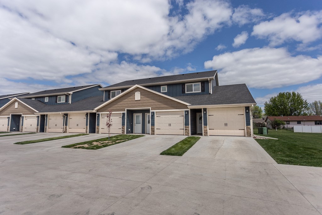 the front of a house with a driveway and garage doors