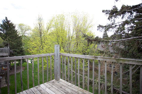 a deck with a view of a garden and trees