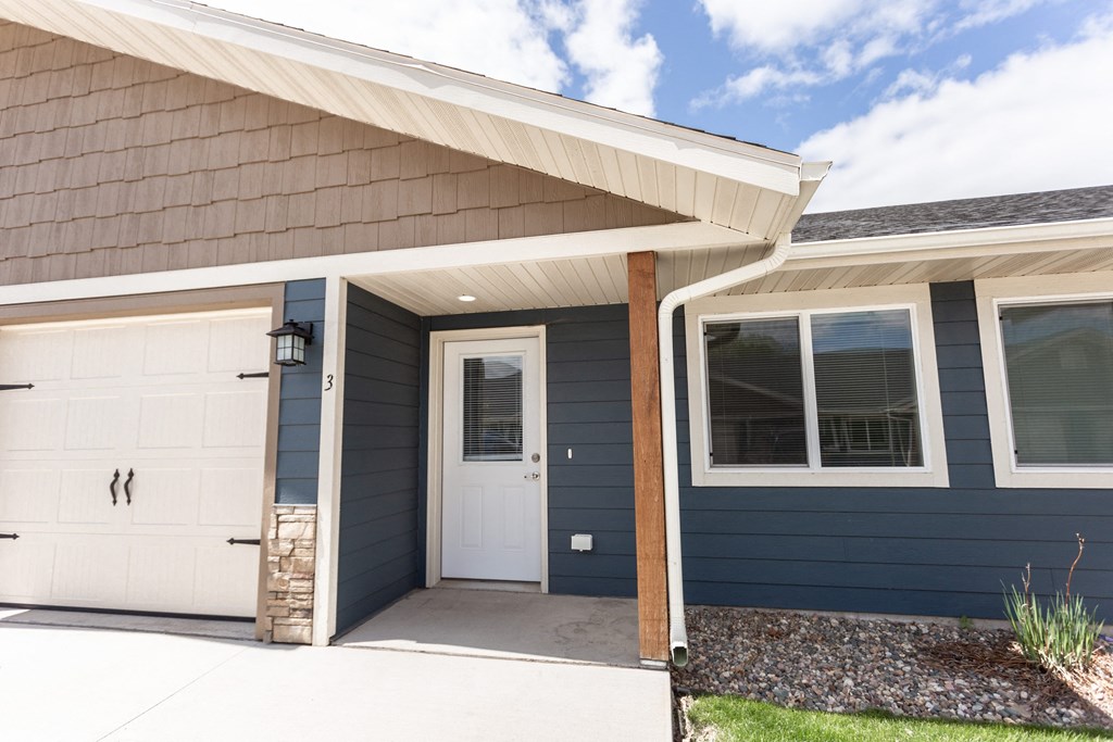 the front of a blue house with a white door