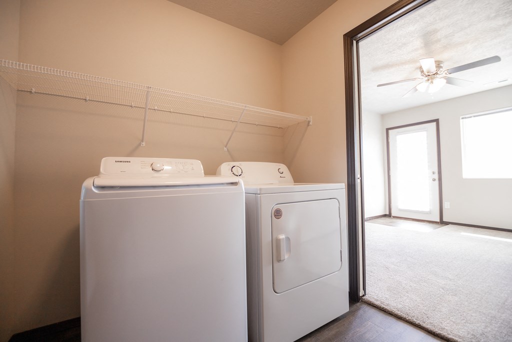an empty laundry room with two washes and a dryer in it