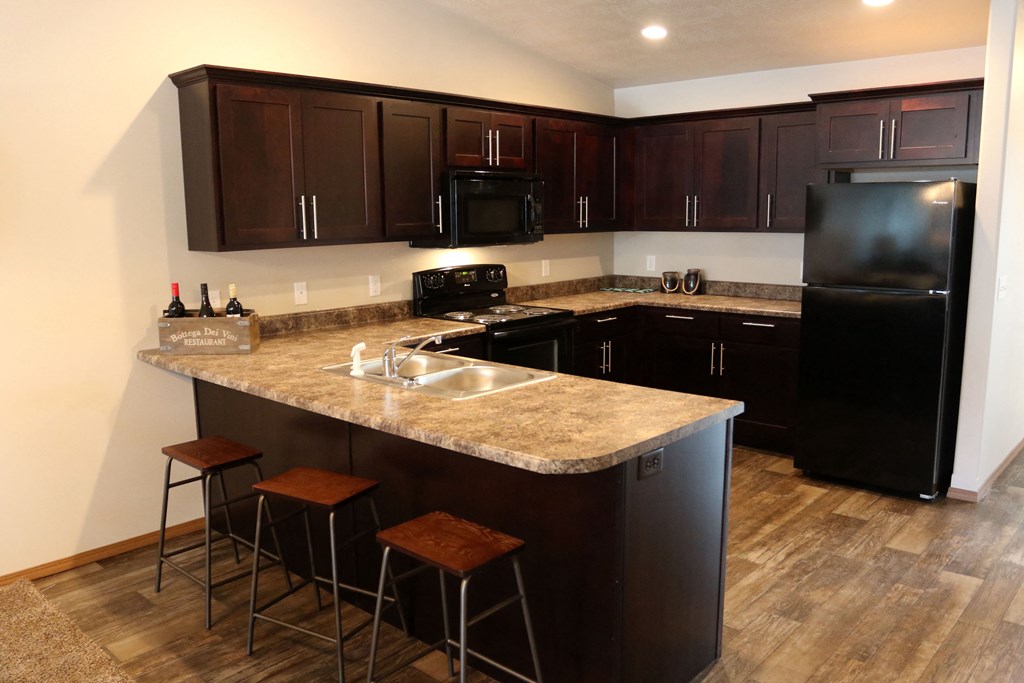 a kitchen with black appliances and a granite counter top