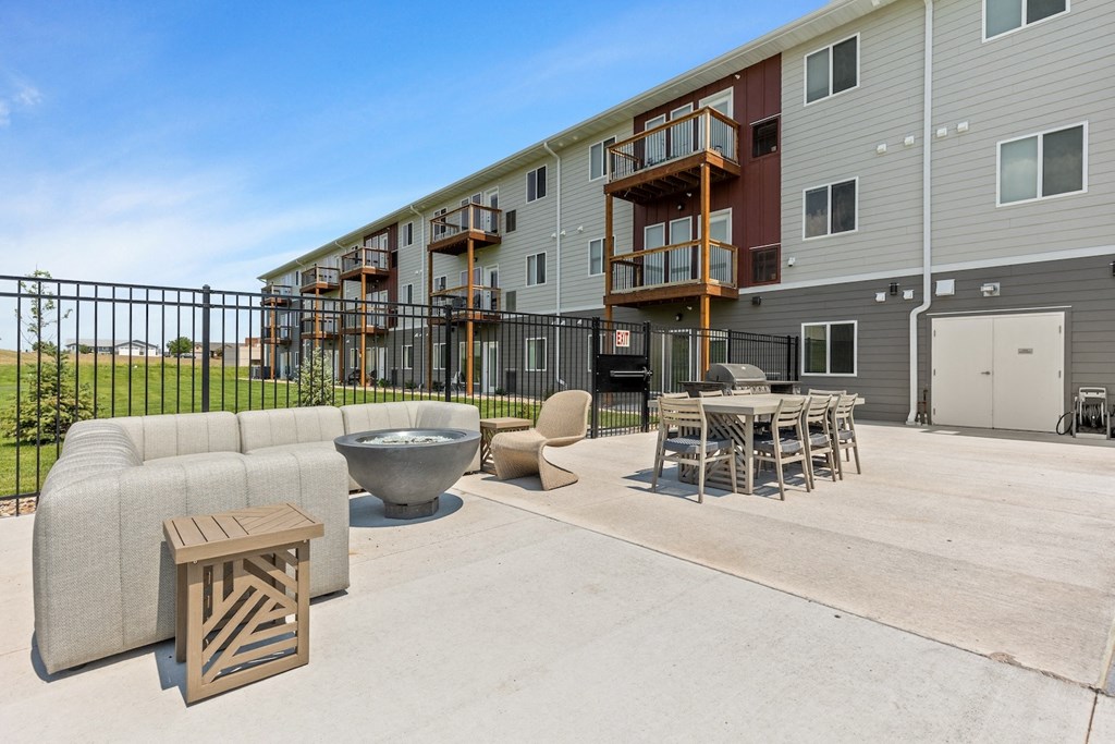 our apartments have a large patio with furniture and a fire pit