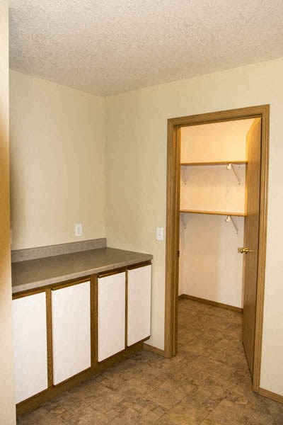 an empty kitchen with an open door to a closet