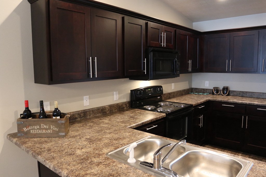 a kitchen with dark wood cabinets and granite counter tops