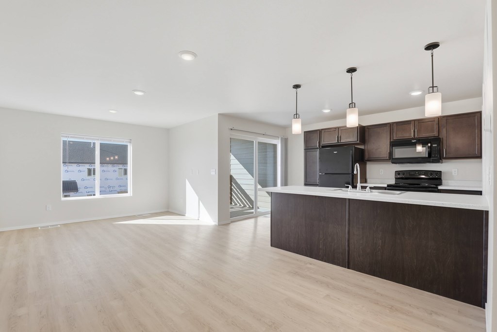 A modern kitchen with dark wood cabinets and a white countertop.