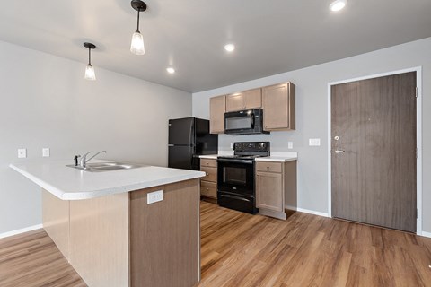 a kitchen with an island and a refrigerator and a sink
