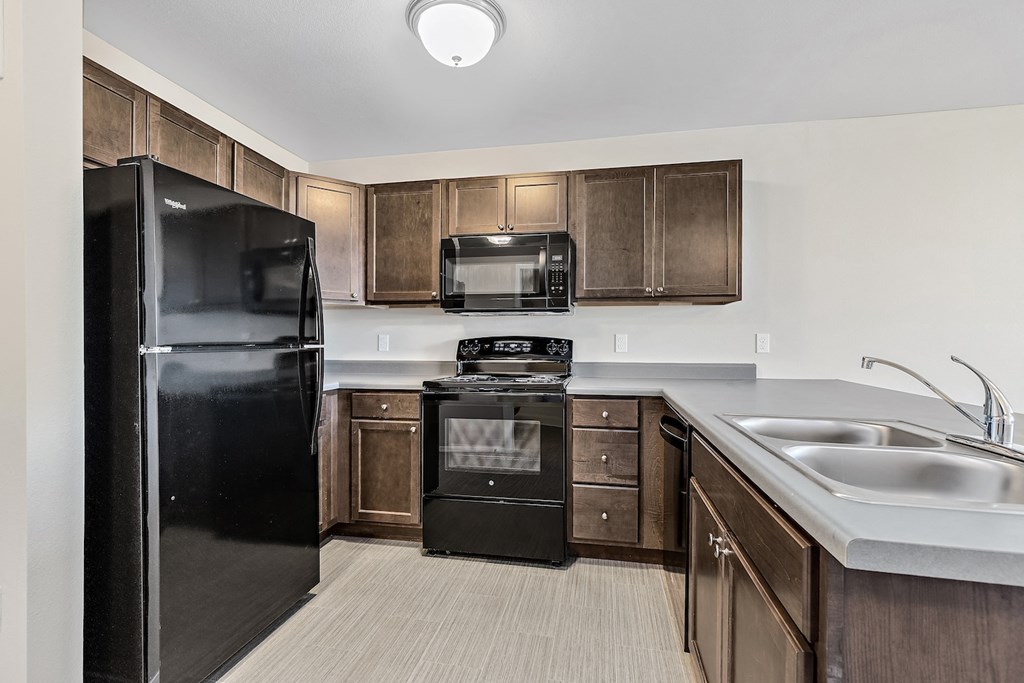a kitchen with black appliances and wooden cabinets