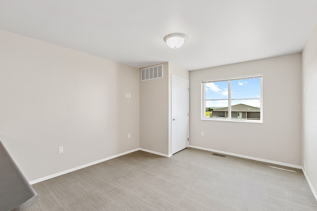 an empty room with a window and a door