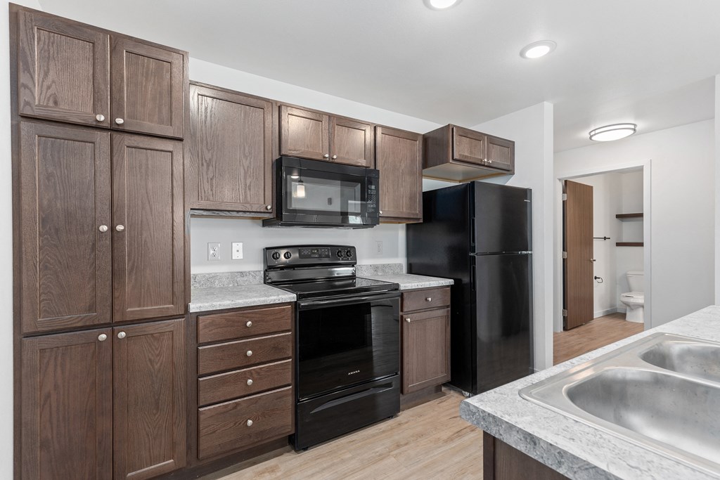 a kitchen with black appliances and wooden cabinets