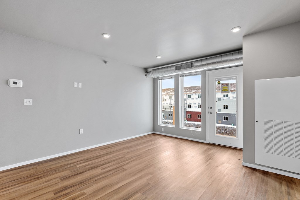 an empty living room with wood flooring and sliding glass doors