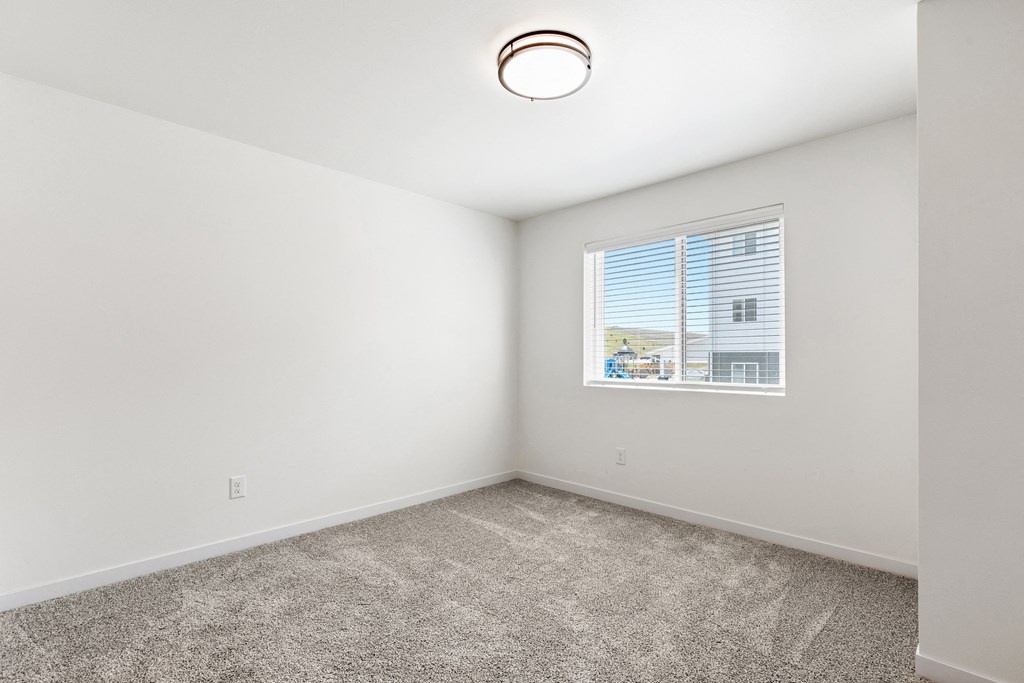 an empty room with carpet and a window