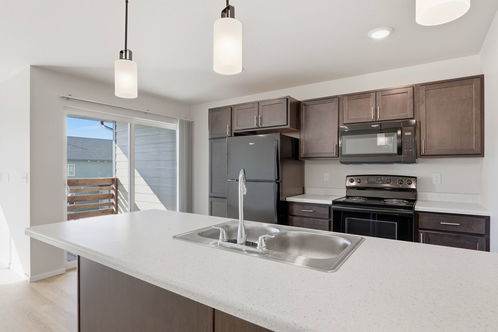 A modern kitchen with a large island and stainless steel appliances.