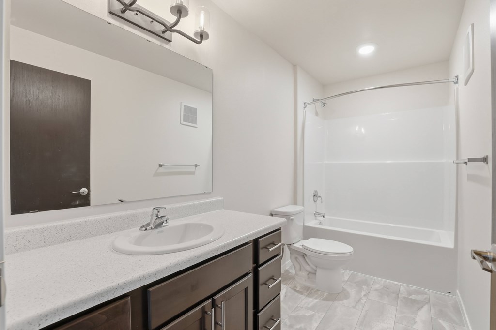 A white bathroom with a sink, toilet, and bathtub.