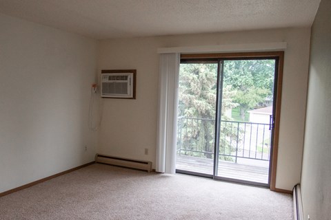 an empty living room with a door to a balcony