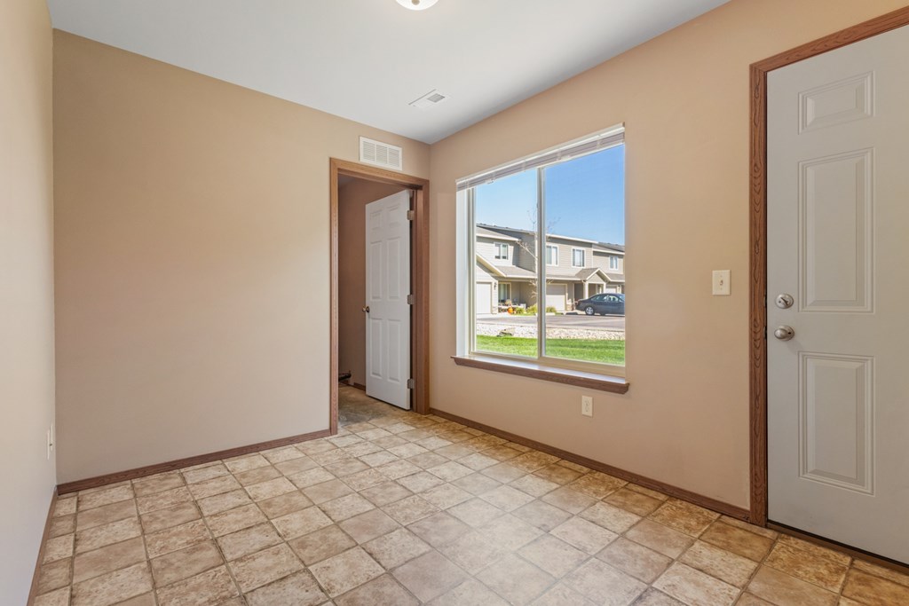 A room with a tiled floor and a view of a building outside the window.