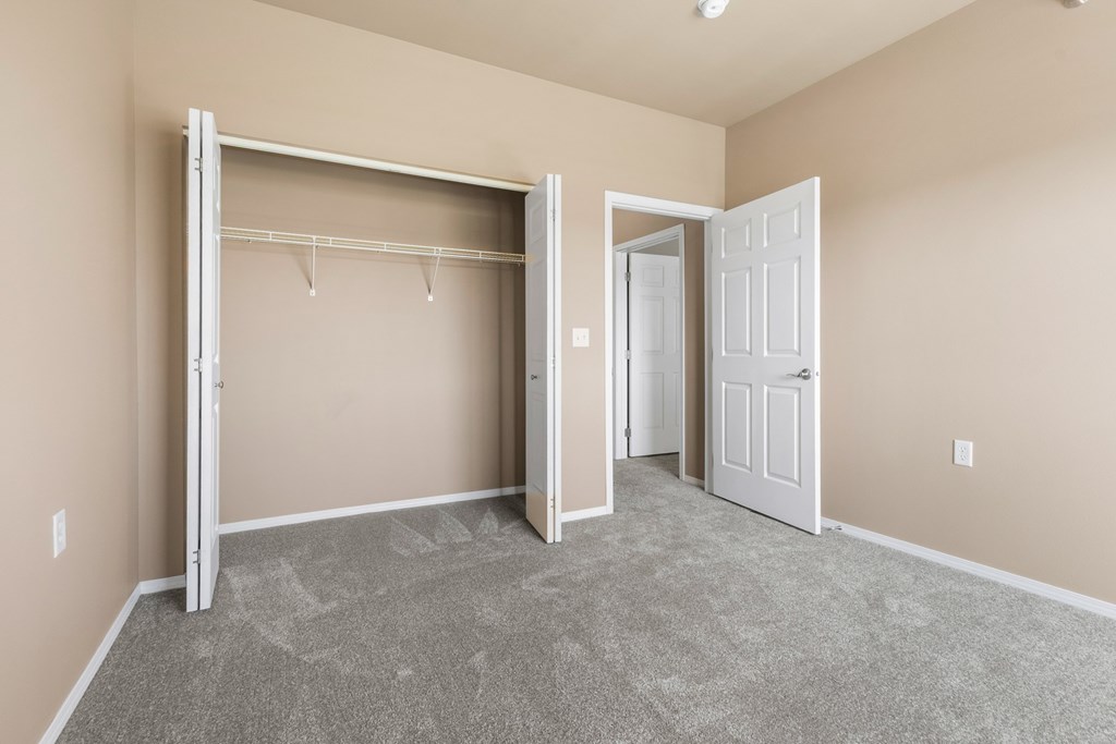 A room with a grey carpet and a white door.