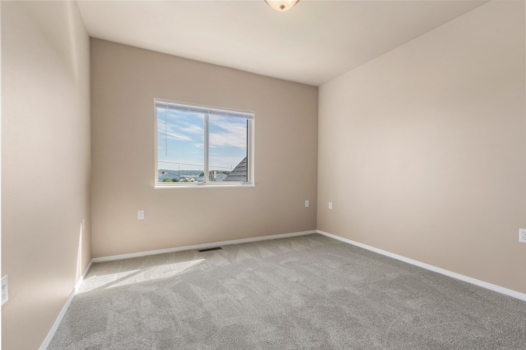 A room with a large window and carpeted floor.