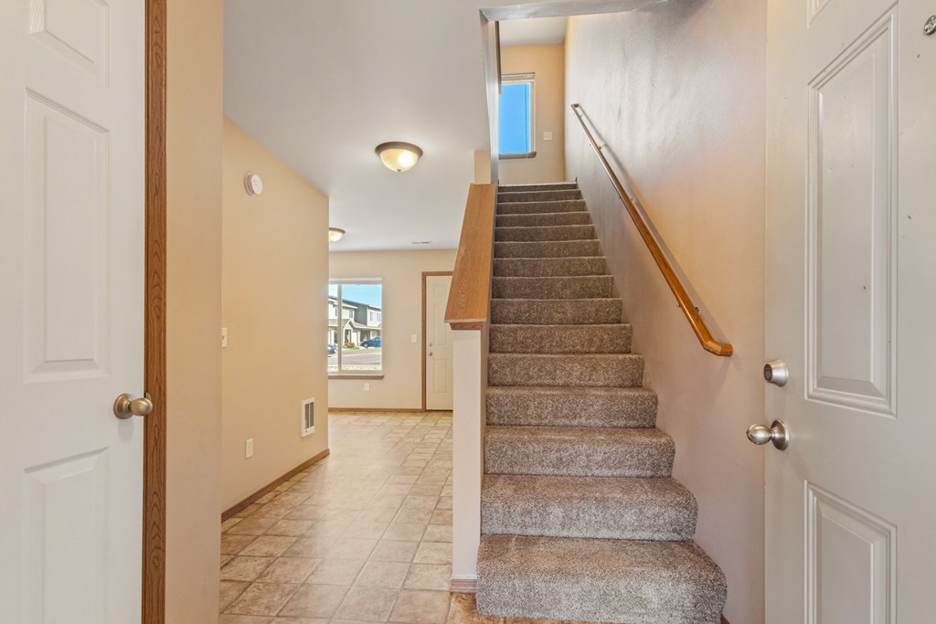 A staircase with a wooden handrail leads to a second floor.