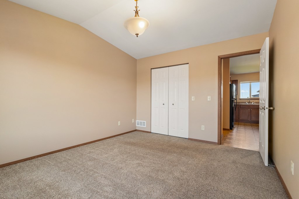 A room with a carpeted floor and a white door.