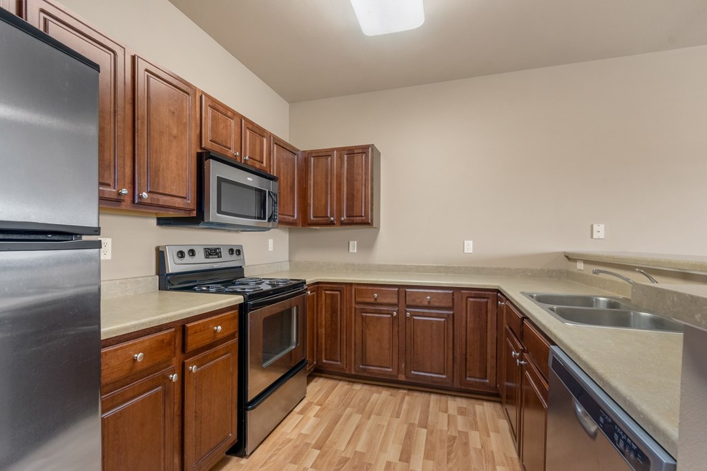 A kitchen with wooden cabinets and stainless steel appliances.