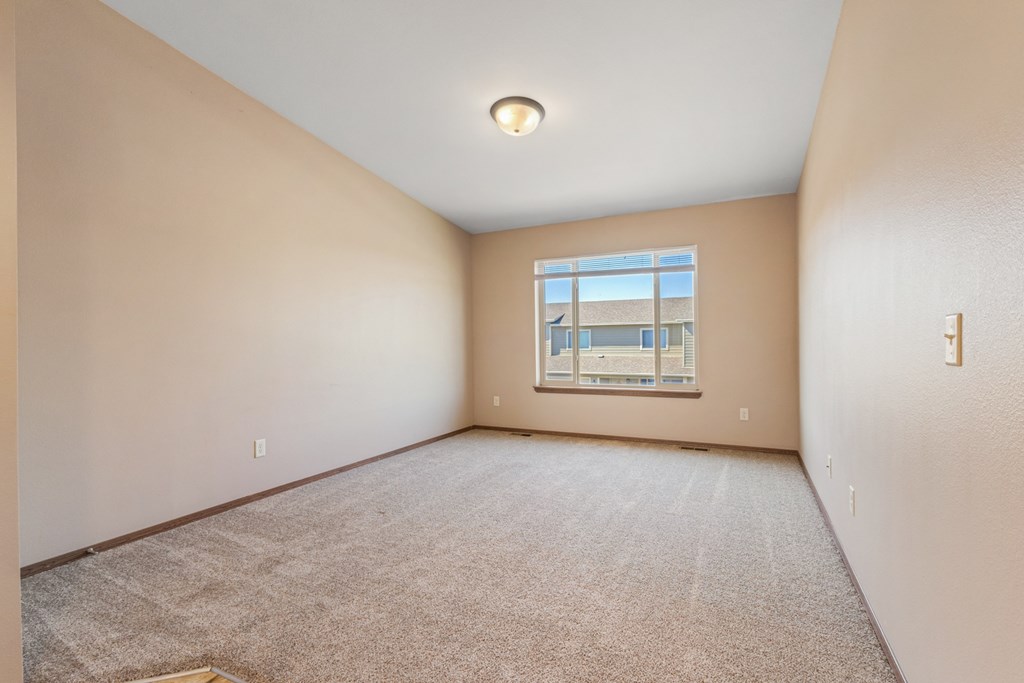 A room with a carpeted floor and a window.