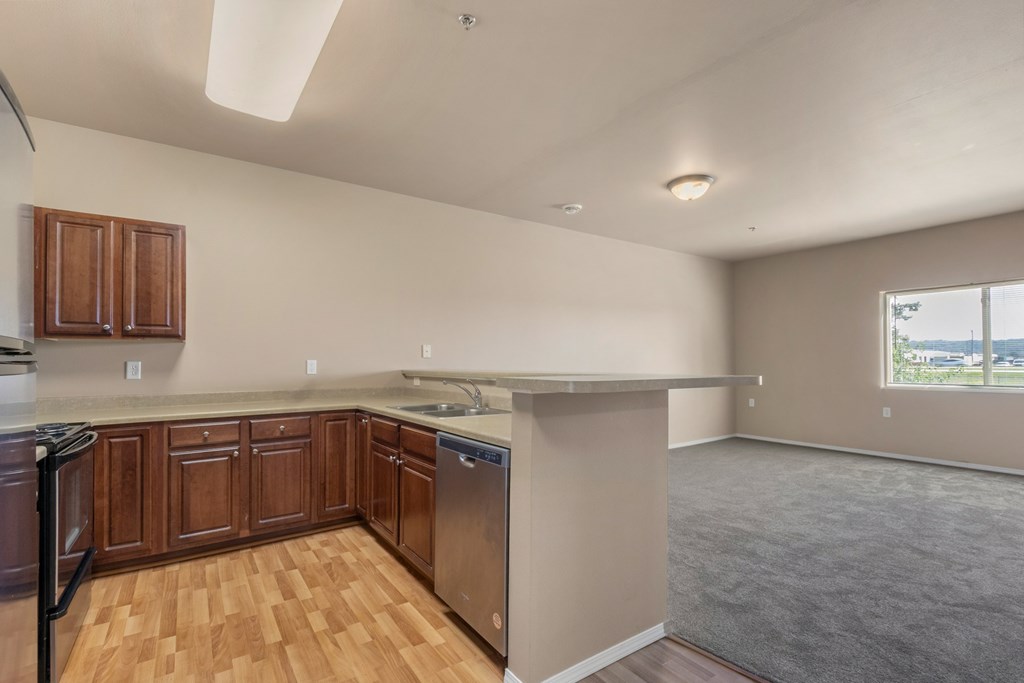 A kitchen with wooden cabinets and a window.