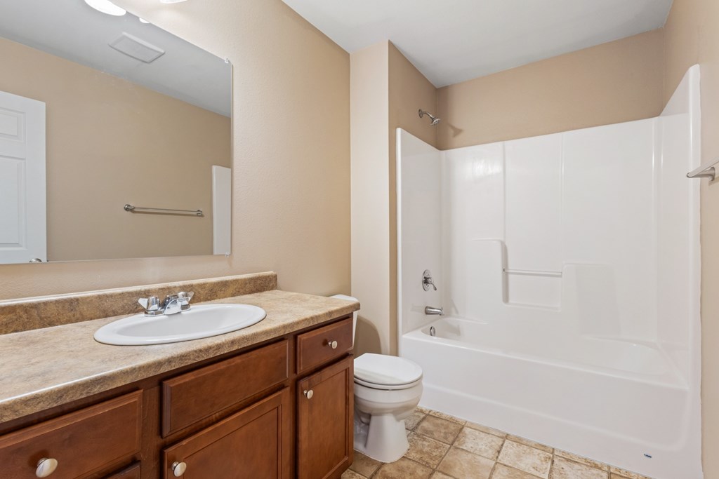 A bathroom with a sink, toilet, and bathtub.