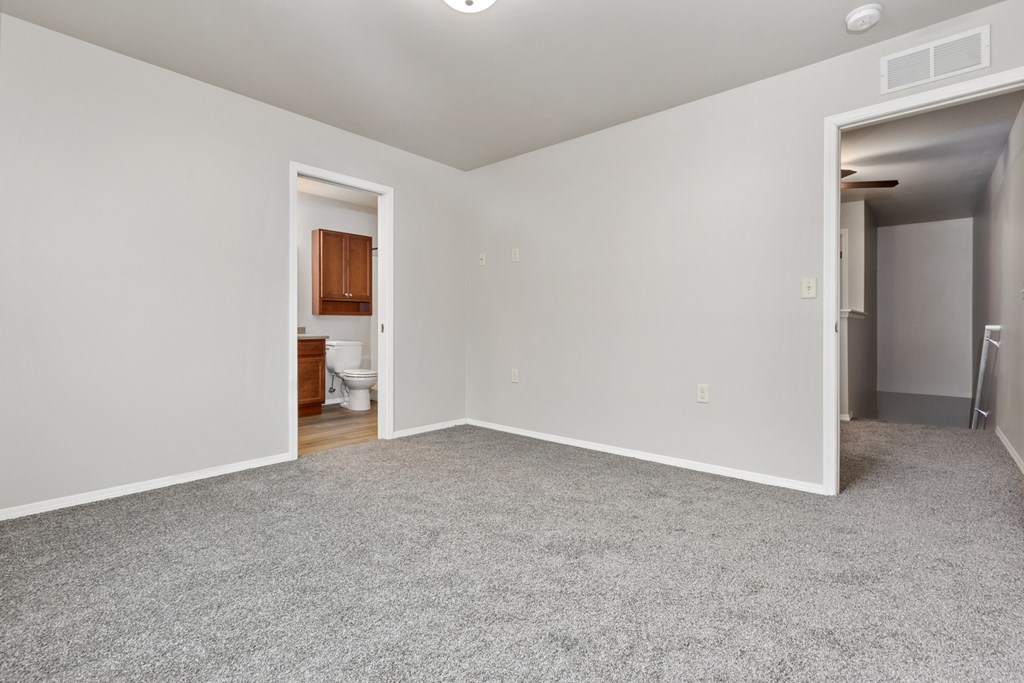 A room with a carpeted floor and white walls.