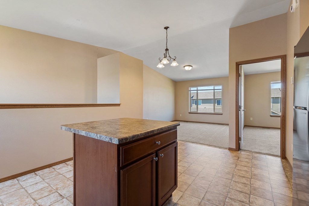 A kitchen with a marble countertop and tile flooring.
