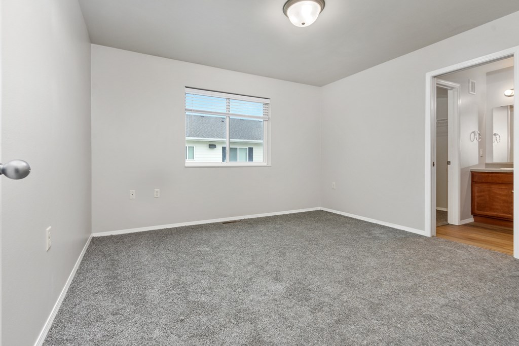 A room with a window and a door leading to another room.