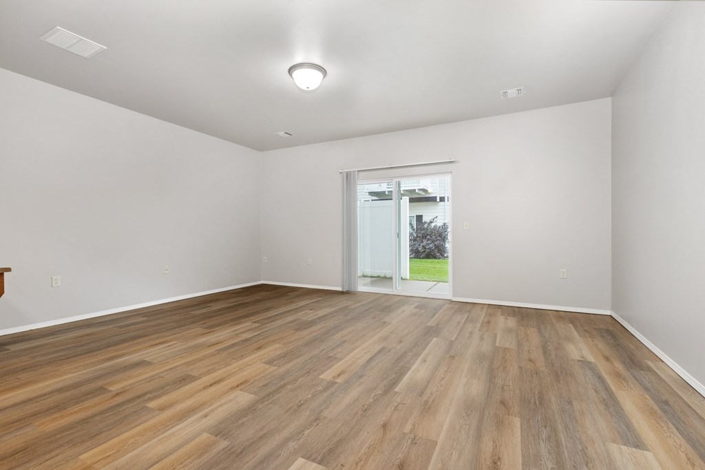 A room with wooden flooring and a sliding glass door.