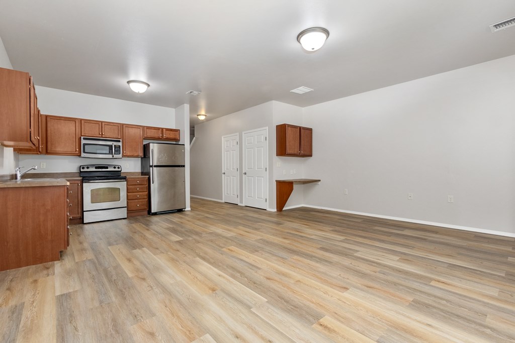 A kitchen with wooden floors and white walls.