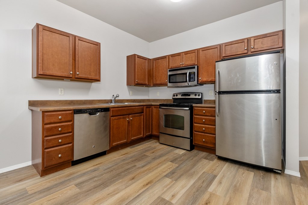 A kitchen with wooden cabinets and stainless steel appliances.
