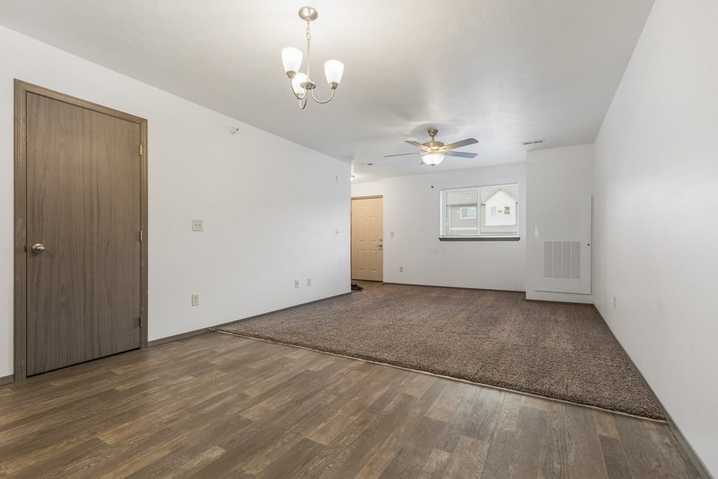 A room with a brown door and a ceiling fan.