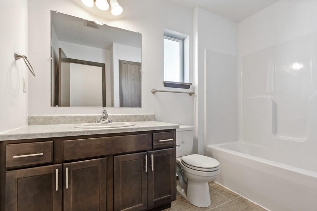 A bathroom with a white toilet and a white bathtub.