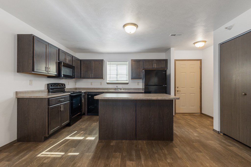 A kitchen with dark wood cabinets and a white countertop.