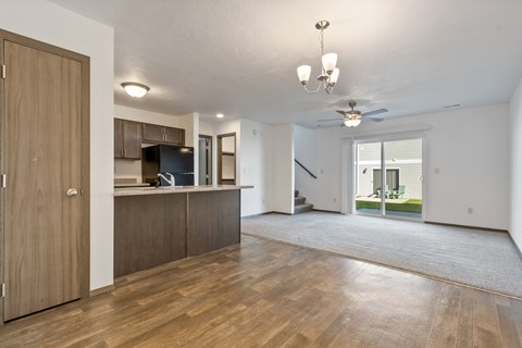 A spacious living room with wooden floors and a ceiling fan.