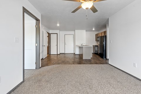 A spacious room with a ceiling fan and a carpeted floor.