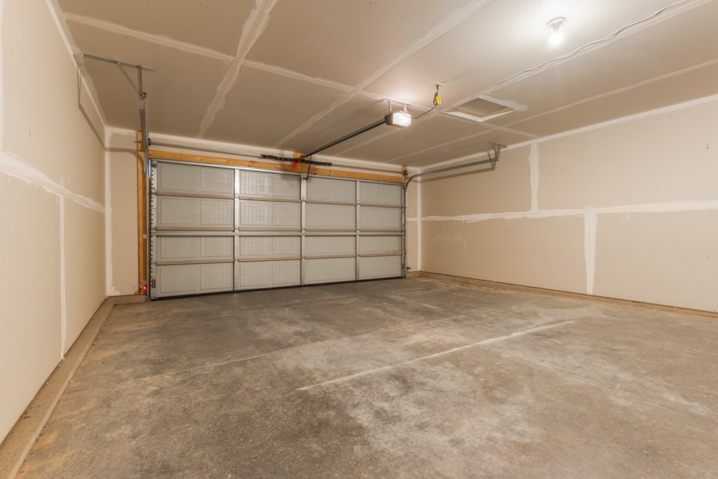 A garage with a white door and a brown floor.