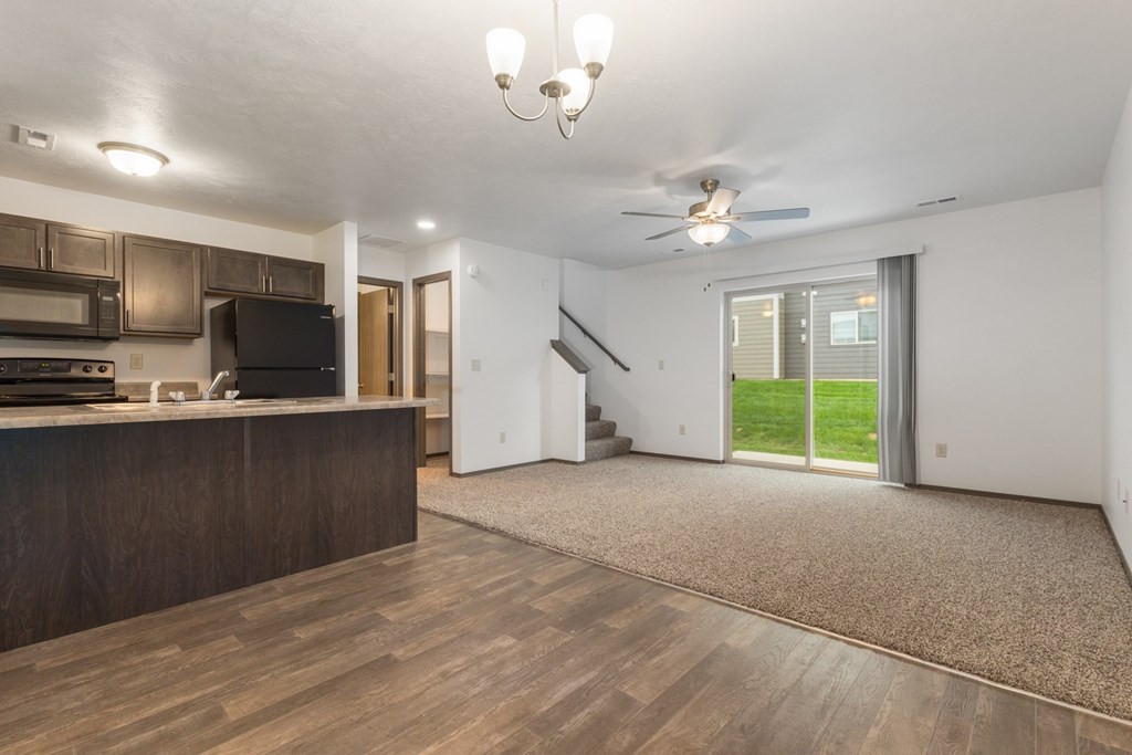 A spacious living room with a staircase leading to the upper floor.