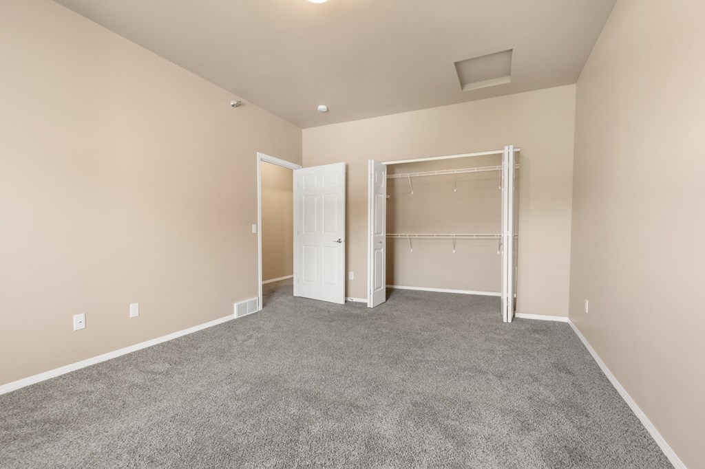 A large, empty room with a carpeted floor and white walls.