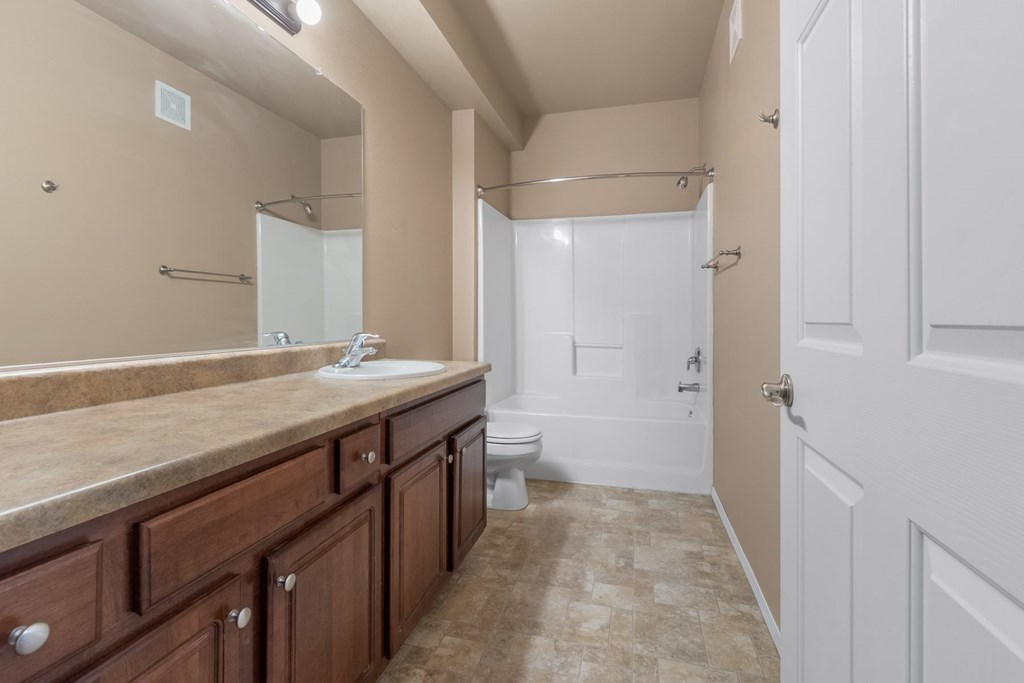 A bathroom with a sink, mirror, and toilet.