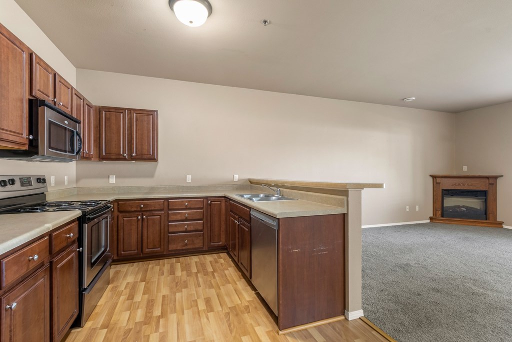 A kitchen with wooden cabinets and a stove top oven.